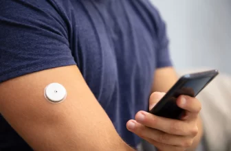 Glucose monitor without finger pricks wearable sensor on arm showing real time blood sugar levels
